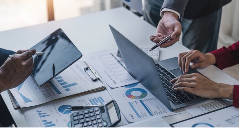 Business people meeting using laptop computer, calculator, notebook, stock market chart paper for analysis