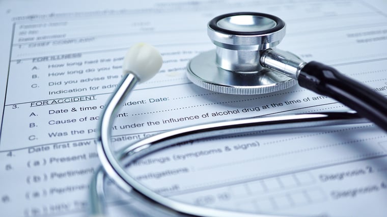 Stethoscope on top of health insurance document