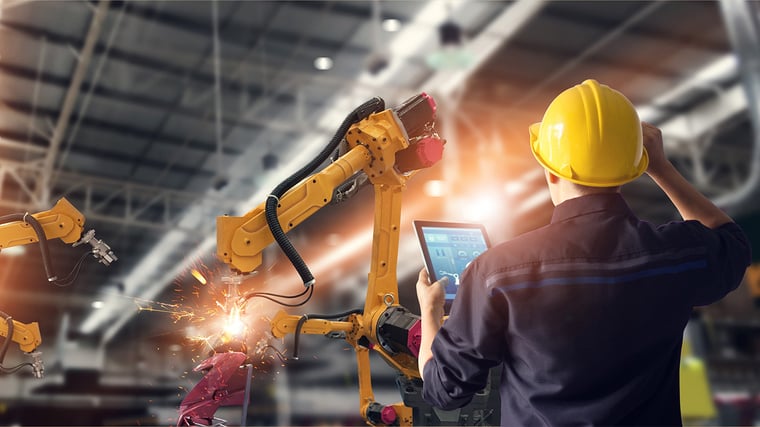 Engineer using tablet check and control automation robot arms machine in intelligent factory industrial on monitoring system software. Welding robotics and digital manufacturing operation.